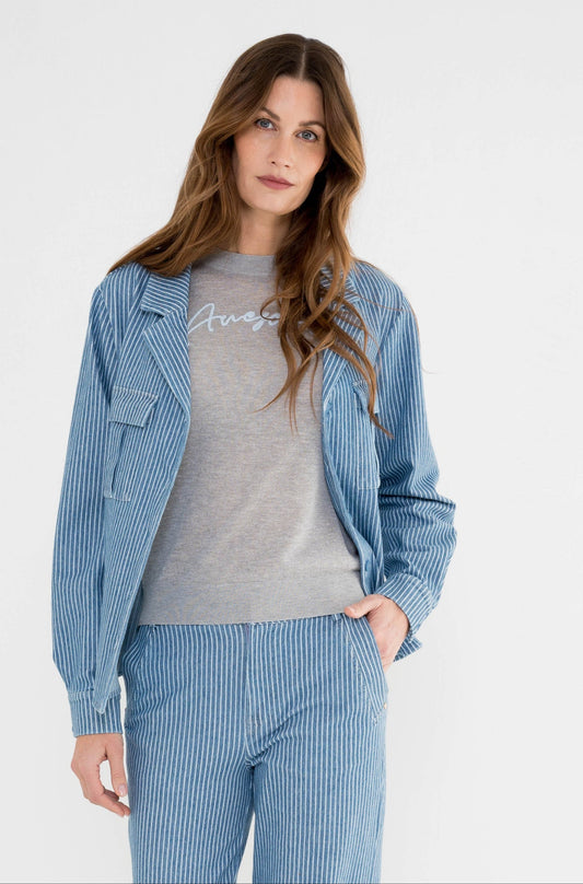 model draagt een blauw gestreepte set met een broek en blouse van dezelfde stof