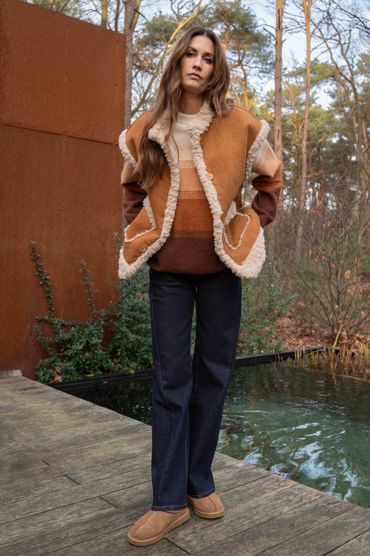 herfstoutfit met donkere denim jeans lisboa met gestikte paneelnaden met een trui en warm teddy giletje 