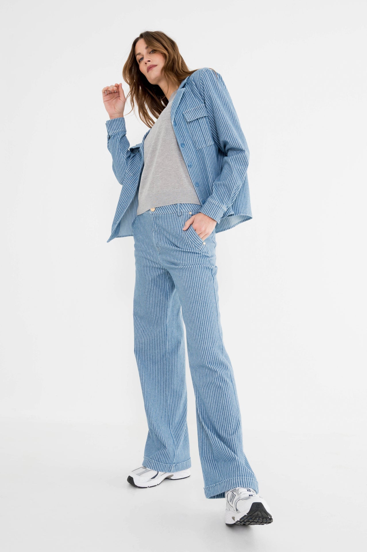 vera blauwgestreepte blouse met een stoere blauw gestreepte jeans gecombineerd met een lichtgrijs t-shirt met de tekst awesome op de borst