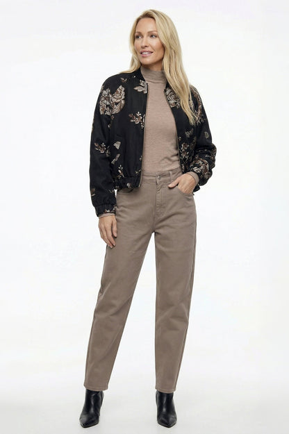 zandkleur barrel jeans gecombineerd met een beige coltrui en stoere bomberjack met bloemenmotief